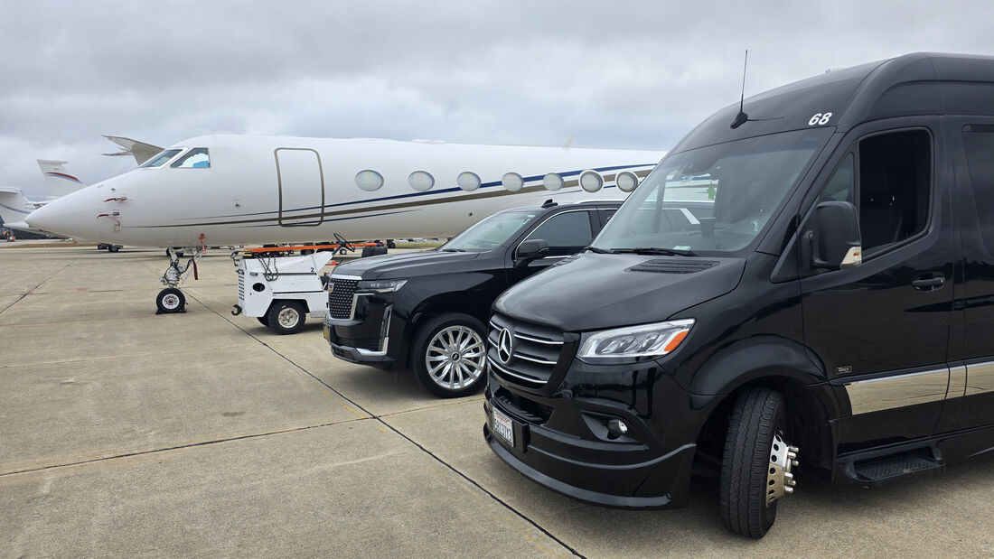 SFDRIVEN fleet vehicles on the tarmac beside a private jet